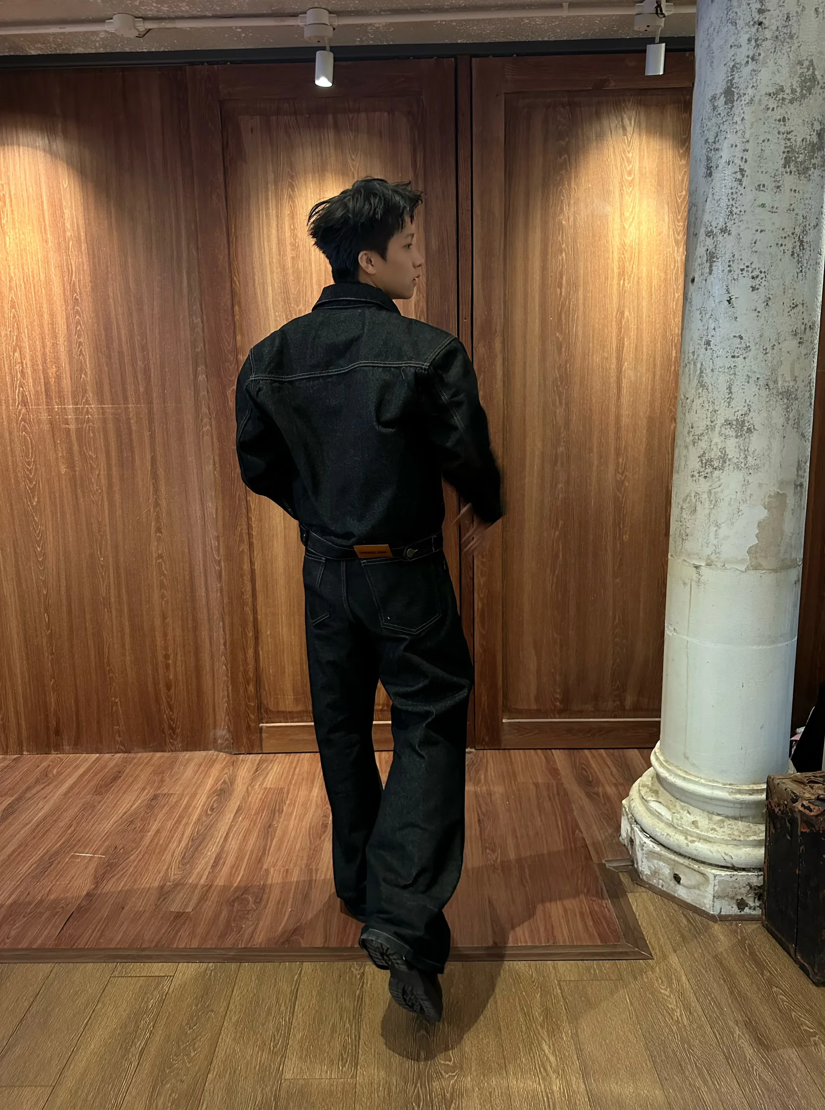 Nguyễn Khánh Hưng showing the back silhouette of a dark denim look